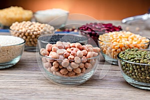 Peanuts in a bowl wood table. The peanut also known as the groundnut  or goober or monkey nut is a legume crop grown mainly for it