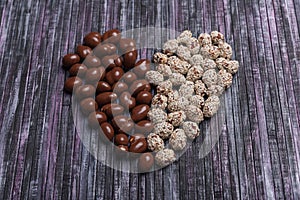 Peanuts in chocolate. Peanut with caramel and sesame seeds. Sweet peanut posted heart.