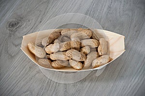 Peanuts in a eco, wooden container  on wooden background