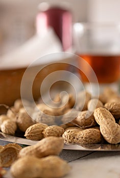 Peanuts in the foreground next to a summer snack on an out-of-focus background