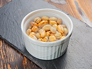 Peanuts fried with salt in a small Cup on a black stone Board