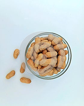 Peanuts in a glass bowl, on a white background