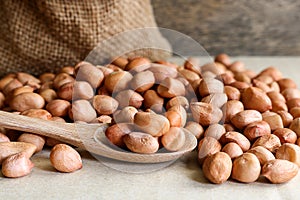 Peanuts in hemp sack on wooden background