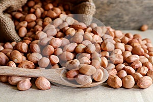 Peanuts in hemp sack on wooden background