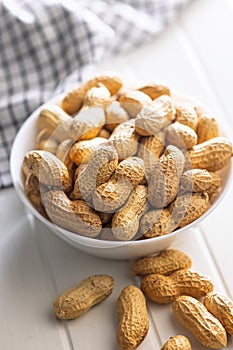 Peanuts in shell. Groundnuts in bowl on white table