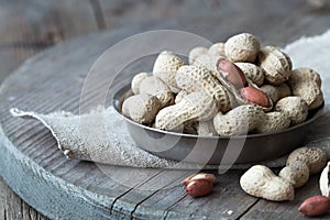 Peanuts in the shell and peeled close up in a cup. Background with peanuts. Roasted peanuts in the shell and peeled on a backgroun