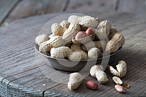 Peanuts in the shell and peeled close up in a cup. Background with peanuts. Roasted peanuts in the shell and peeled on a backgroun