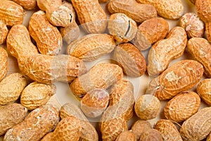 Peanuts in shelles on wooden table as a background