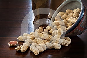 Peanuts in shells and rustic ceramic tableware on a dark table