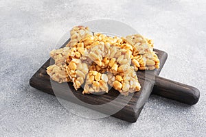 Peanuts in sugar glazed, oriental sweetness of brittle. Kozinaks are broken into pieces on a wooden Board, copy space