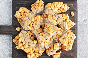 Peanuts in sugar glazed  oriental sweetness of brittle. Kozinaks are broken into pieces on a wooden Board  copy space. top view