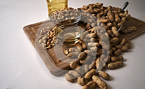 Peanuts whole and shelled on a wood board and a scoop