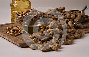 Peanuts whole and shelled on a wood board and a scoop