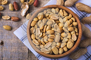 Peanuts in wooden bowl on natural wooden desk