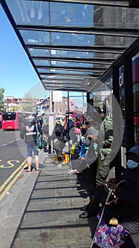 Peaple waiting at bus stop lewisham south londonuk