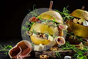 Pear appetizer with prosciutto or spanish jamon, pears, camembert, walnut and microgreen. Food recipe background