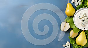 Pear and blue cheese banner with copy space. Whole and halfed pears and pices of blue cheese on light blue concrete background. photo