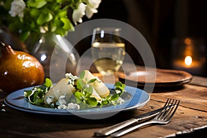 Pear and blue cheese salad on a rustic wooden table with a glass of white wine. Pear salad made from green salad leaves, rocket