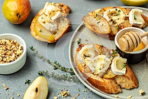 Pear and brie crostini with honey, walnut and thyme, New Years Eve or Christmas party appetizer. banner, menu, recipe place for