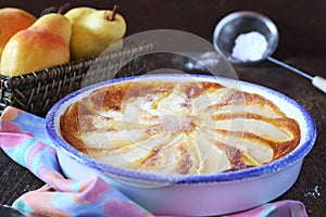 Pear clafoutis and yellow pears in wicker basket