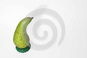 Pear conference on a round stand drop shadow on white background. beautifully curved, with short stalk, green peel with gray-brown
