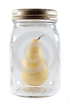 Pear beside a glass jar on isolated background
