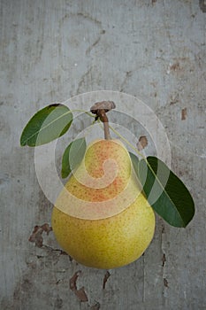 Pear with leaves on wooden board