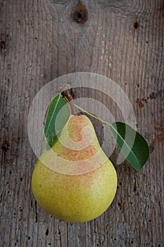 Pear with leaves on wooden board