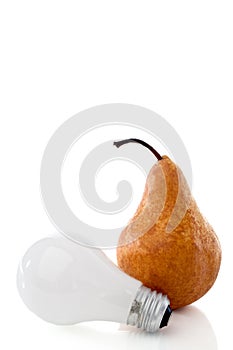 A pear and lightbulb on a white reflective