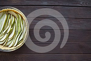 Pear pie on brown wooden background, top view. Copy space, space for text