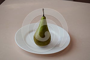 Pear on a white plate. Still life.