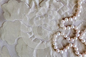 Pearl background with beautiful silk texture and string of natural rose pearl necklace