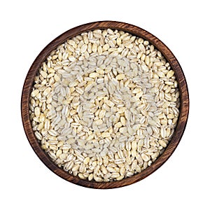 Pearl barley groats in wooden bowl isolated on white background, top view