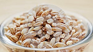 Pearl barley heap in a glass bowl rotating