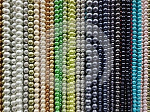 Colorful pearl beads in rainbow gradient creating vibrant background