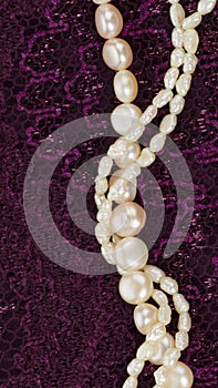 Pearl beads on a purple lace fabric