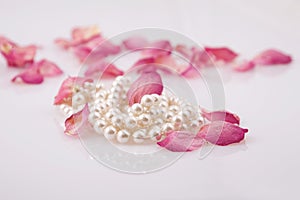 Pearl beads and red roses petals