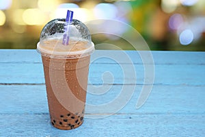 Pearl Bubble milk tea with ice in plastic cup on wooden