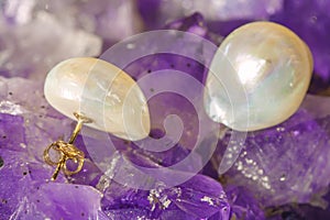 Pearl earrings on ametyst background
