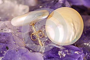 Pearl earrings on ametyst background