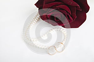 Pearl heart, a rose and wedding rings