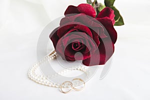 Pearl heart, a rose and wedding rings