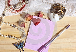 Pearl Jewelry and Butterfly Broach With Lace and Dried Roses on Wooden Background With Note Paper