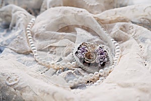 Pearl necklace and antique brooche on lace.