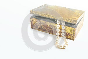 Pearl necklace, beads in antique metallic vintage casket on white background. Oldfashioned decoration from grandma`s jewelry box