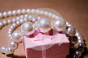 Pearl necklace on a pink box. Pearl jewelry. Imitation of pearls. Not a natural pearl. Bijouterie. Luxury and wealth photo