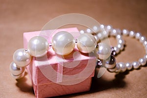 Pearl necklace on a pink box. Pearl jewelry. Imitation of pearls. Not a natural pearl. Bijouterie. Luxury and wealth photo