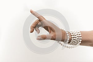 Pearl necklace on senior woman hand cut out on white background. Luxury jewelry on female hand with French manicure