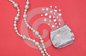 Pearl necklace and silver purse with shiny gems