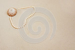 Pearl necklace on white fine sand with sea shell. Luxury resort, ocean or sea wedding concept